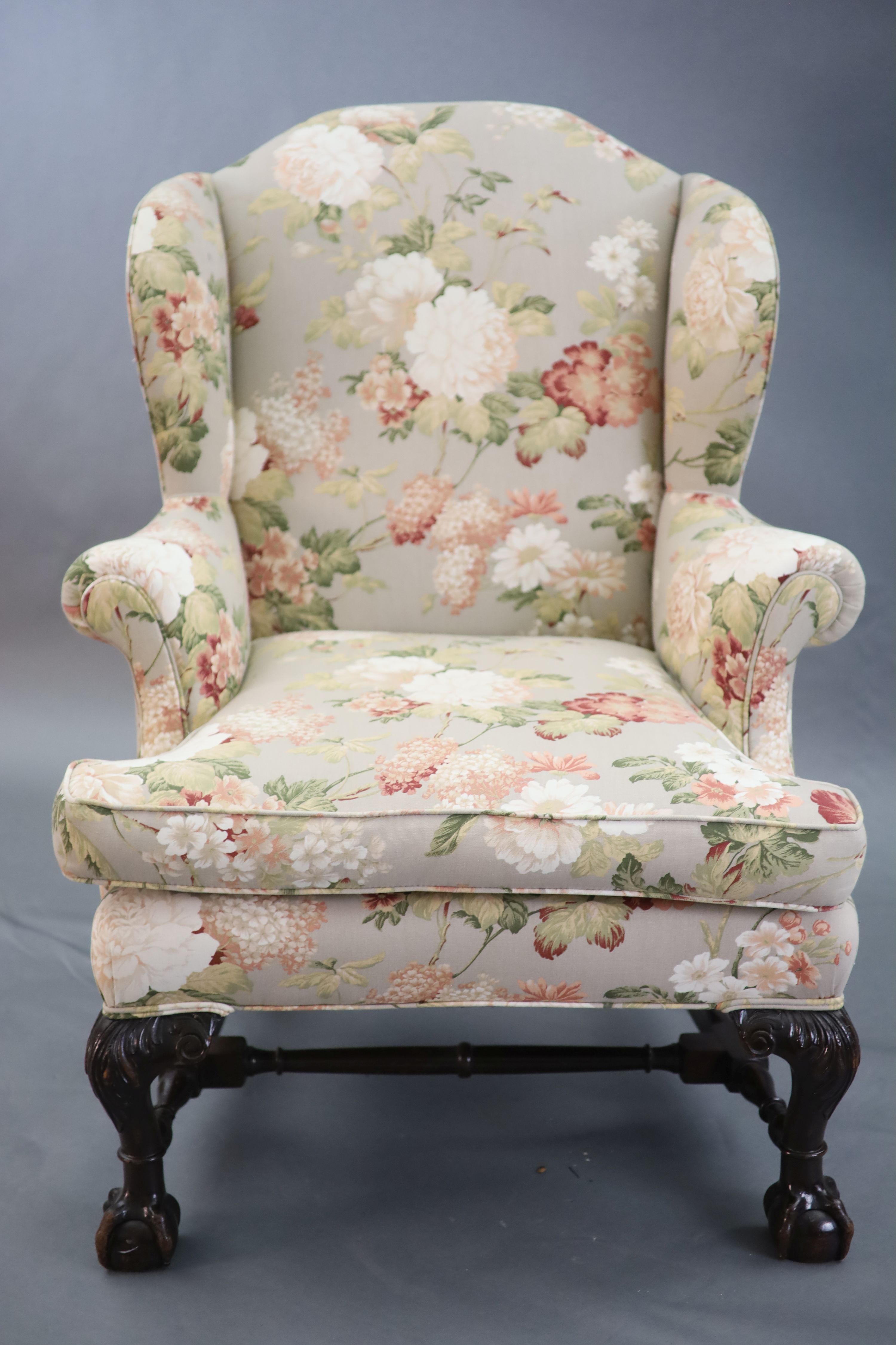 A Chippendale revival wing armchair together with a matching contemporary footstool